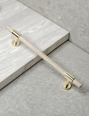 SIGNATURE slim pull bar 182 mm in Polished Brass/Oak. Modern cabinet hardware made of solid brass by BRANDT Collective.