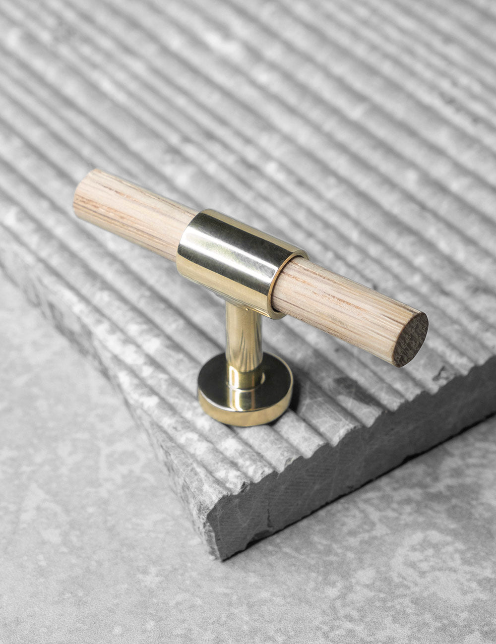 REFINED T-bar 54 mm in Polished Brass/Oak. Modern kitchen hardware made of solid brass by BRANDT Collective.