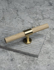 SIGNATURE 20 T-bar handle 113 mm in Satin Brass/Oak. Luxury cabinet hardware made of solid brass by BRANDT Collective. 