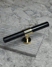 SIGNATURE 20 T-bar handle 113 mm in Polished Brass/Black Horn. Luxury cabinet hardware made of solid brass by BRANDT Collective.