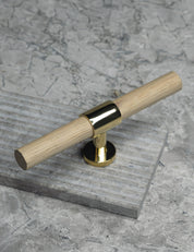 SIGNATURE 20 T-bar handle 113 mm in Polished Brass/Oak. Luxury cabinet hardware made of solid brass by BRANDT Collective. 