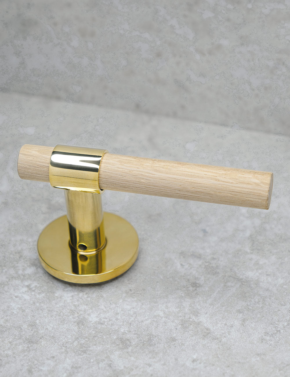 SIGNATURE door handle in Polished Brass/Oak. Modern door hardware made of solid brass by BRANDT Collective.