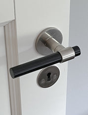 SIGNATURE door handle in Brushed Nickel/Black Horn. Modern door hardware made of solid brass by BRANDT Collective.