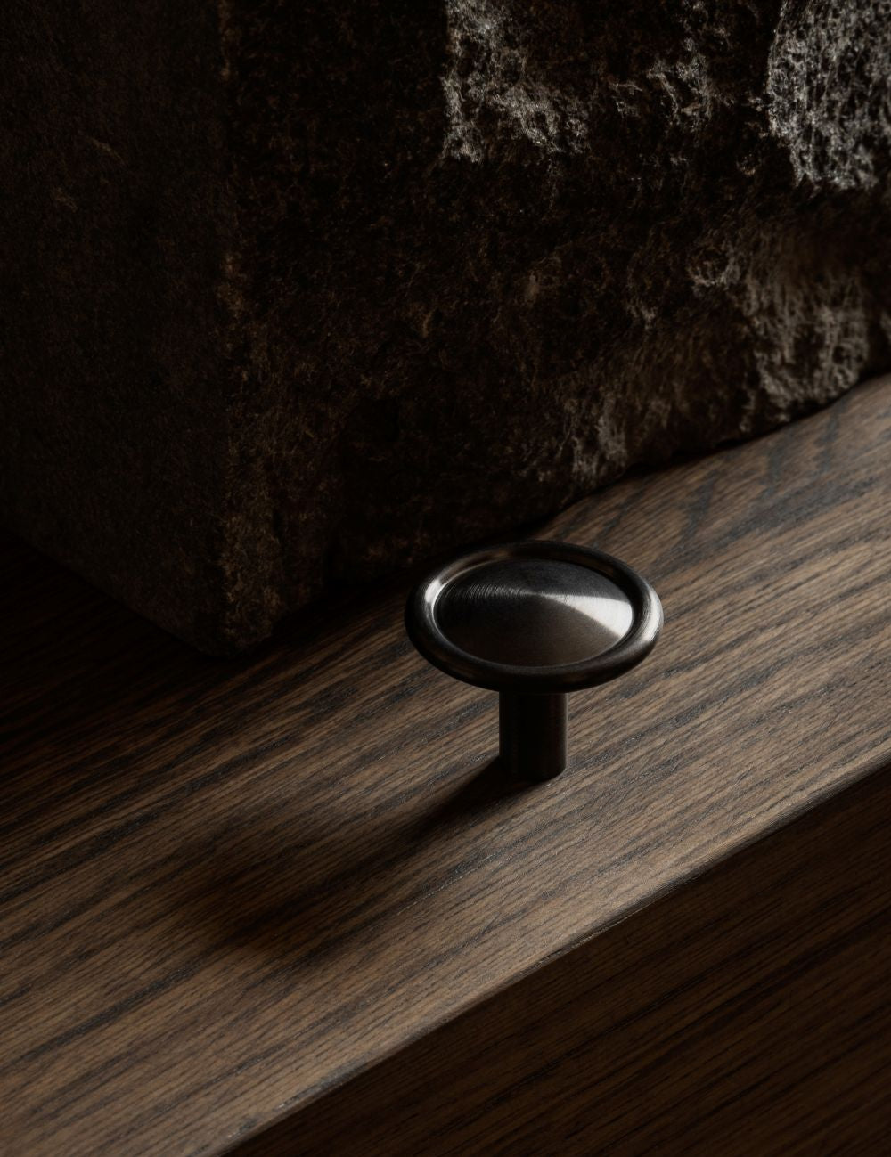 BUTTON knob in gunmetal black by BRANDT Copenhagen. A hardware collection in collab with Norm architects consisting of knobs, T-bars and pull bars for kitchens and cabinets.