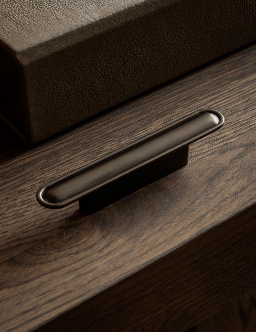 BUTTON pull bar 110 mm in gunmetal by BRANDT Copenhagen. A hardware collection in collab with Norm architects consisting of knobs, T-bars and pull bars for kitchens and cabinets.