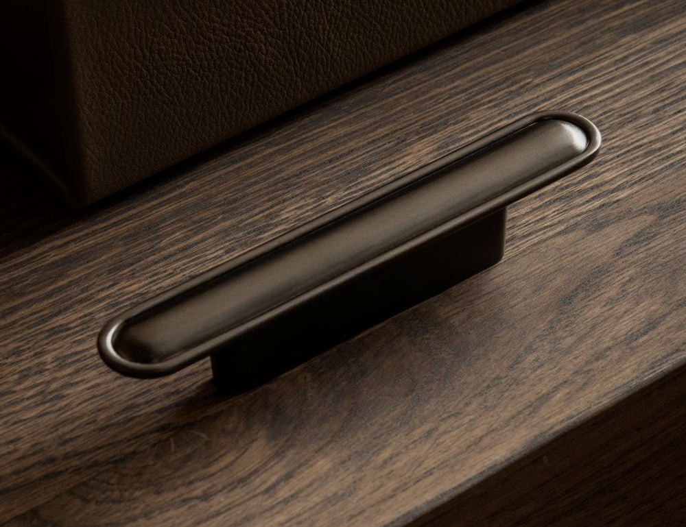 BUTTON pull bar 110 mm in gunmetal by BRANDT Copenhagen. A hardware collection in collab with Norm architects consisting of knobs, T-bars and pull bars for kitchens and cabinets.