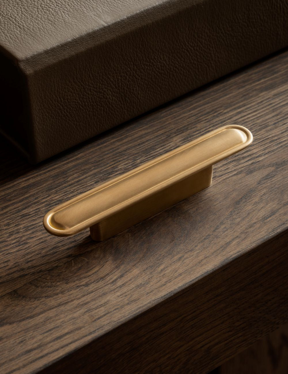 BUTTON pull bar 110 mm in satin brass by BRANDT Copenhagen. A hardware collection in collab with Norm architects consisting of knobs, T-bars and pull bars for kitchens and cabinets.
