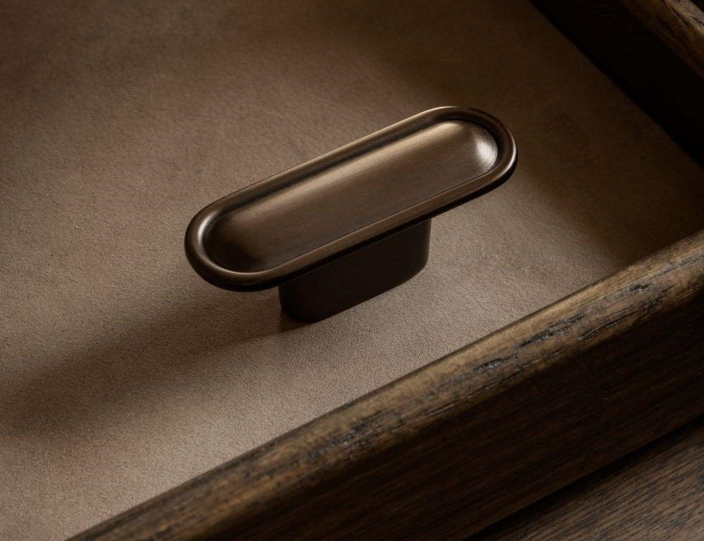 BUTTON T-bar in burnished brass by BRANDT Copenhagen. A hardware collection in collab with Norm architects consisting of knobs, T-bars and pull bars for kitchens and cabinets.
